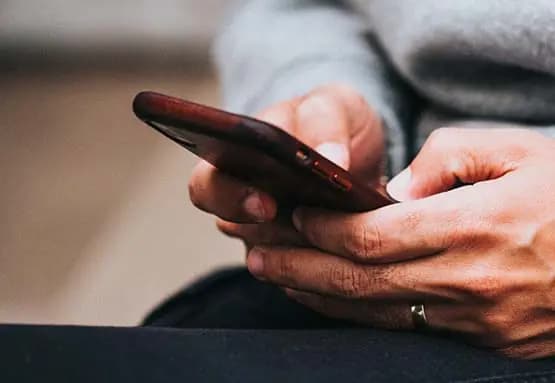 Man typing on phone demonstrating mobile giving.